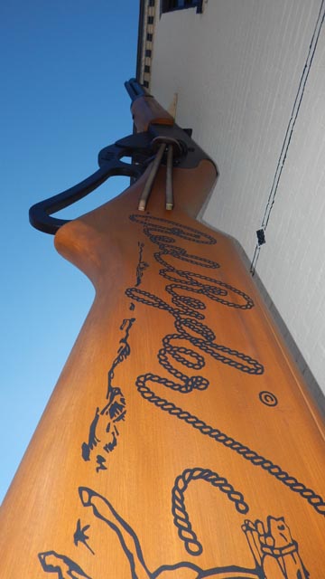Looking up at the World's Largest Daisy BB Gun against a blue sky